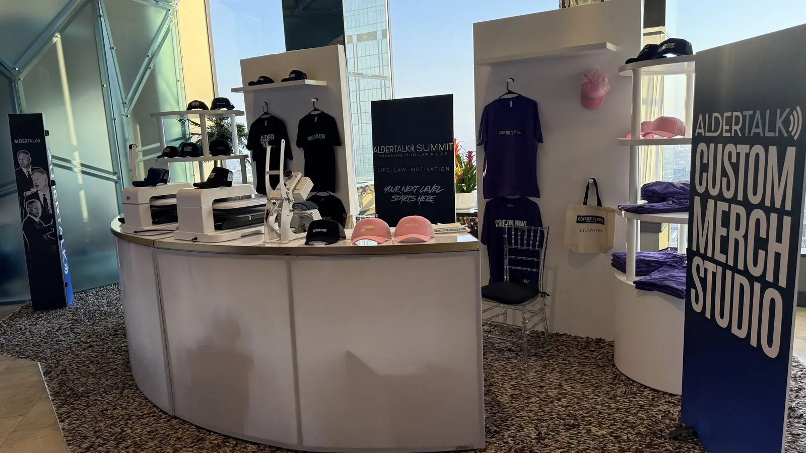 Custom merch station with presses, shelves of apparel, and hats